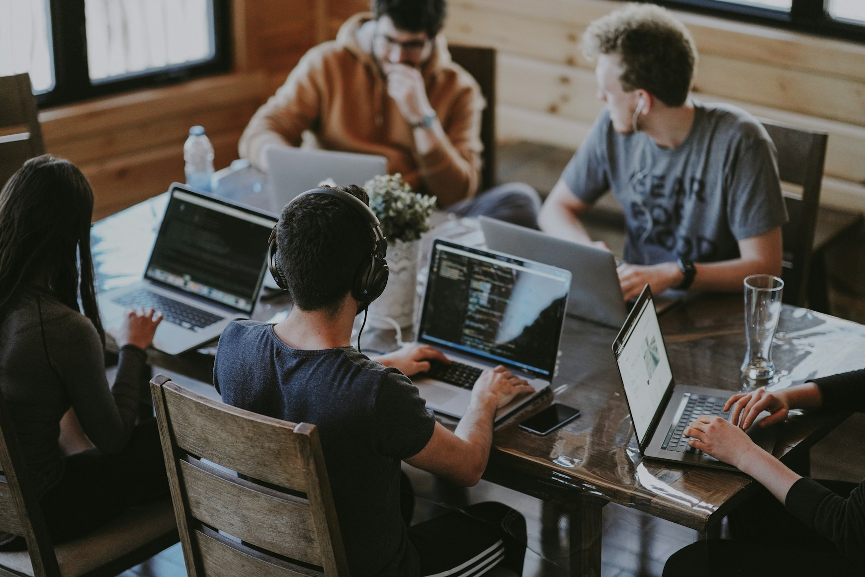 Software developer writing code on dual monitors in a modern office